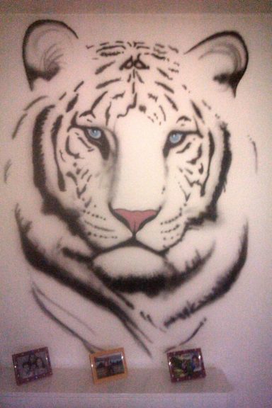 Airbrush artwork of a white tiger with blue eyes.
